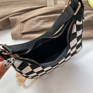 Vintage black and white checkered underarm bag with gold chain strap in a crescent shape