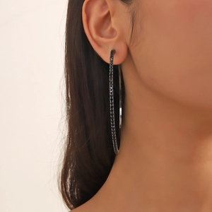 Detail of 8cm oversized black hoop earrings with rhinestones on female model