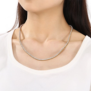 Gros plan d'un collier de tennis doré en zircone porté par un mannequin élégant