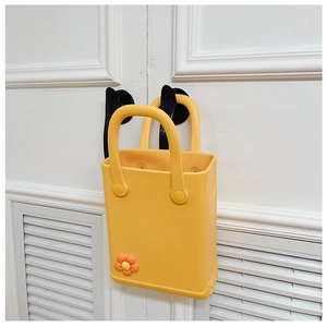 Detail der gelben EVA-Strandtasche mit oranger Blumenverzierung auf weißem Grund