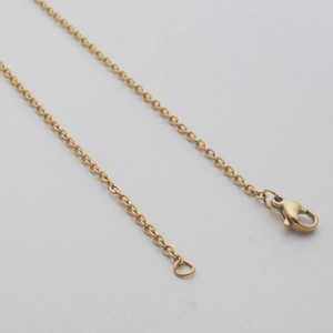 Detailed close-up of golden stainless steel cable chain necklace with lobster clasp