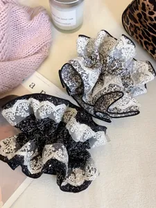 Détail de chouchous floraux avec bord en dentelle en noir et beige sur fond esthétique