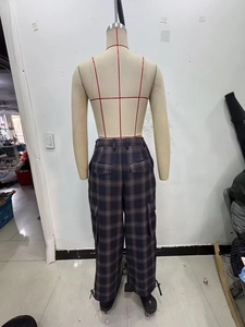 Rear view of brown plaid cargo pants featuring side flap pockets and wide-leg fit on mannequin