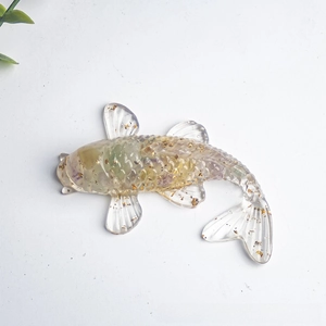 Macro shot of koi fish resin statue with gold foil and colorful dried flower petals