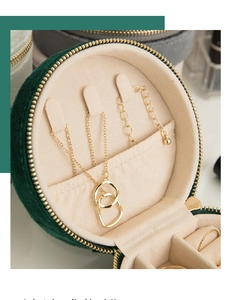Detail view of round emerald velvet jewelry box with necklace hooks and ring slots