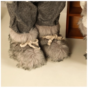 Close-up of plush gray faux fur boots with cotton cord ties for Christmas figurines