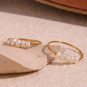 Detail of 18K gold plated rings featuring delicate freshwater pearls on stone