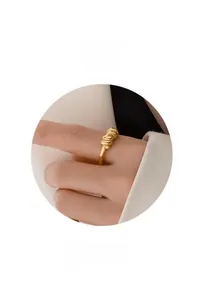 Close-up of golden twisted braided ring for women with high-quality polished metal finish