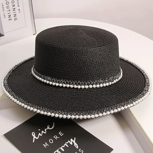 Detail view of woven black flat top straw hat with elegant double-row pearl trim decor