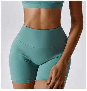 Detailed shot of high-waisted yoga shorts in teal showing flatlock seams and compression fabric