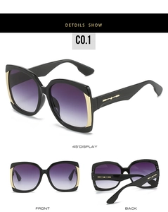 Detailed view of oversized square sunglasses with purple gradient lenses and gold accents