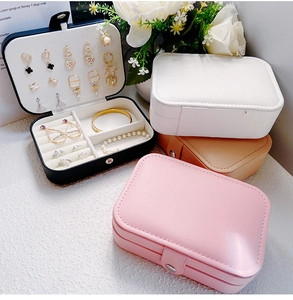 Close-up of portable jewelry boxes in pink, white, black, and khaki with multi-tier storage