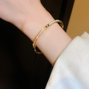Primo piano del bracciale placcato oro con zirconi e intarsio in madreperla