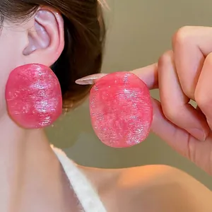 Elegant pink oval stud earrings with brushed texture and translucent resin finish