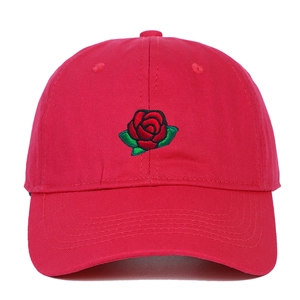 Close-up of detailed rose flower embroidery on red cotton twill baseball cap
