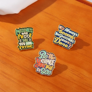 Detailed close-up of a 3-piece vintage metal enamel brooch set with motivational quotes