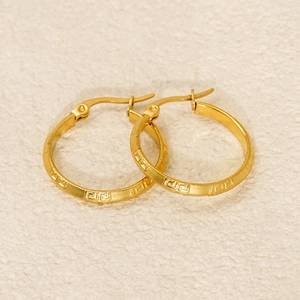 Détail de boucles d'oreilles en titane plaqué or 18K avec gravures grecques ciselées