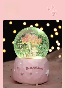Detail of pink cherry blossom snow globe featuring colorful LED lights and Best Wishes text