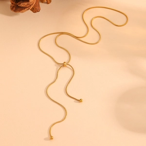 Detail of gold snake chain necklace with adjustable bolo slider and spherical ends