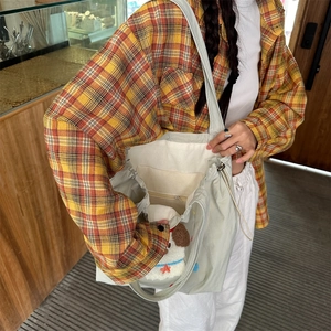 Internal view of a canvas tote bag showing the drawstring closure and functional pockets
