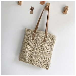 Detail of woven floral pattern on cream tote bag with brown faux leather straps