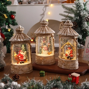 Three illuminated Christmas lanterns with Santa and snowman scenes on a tray