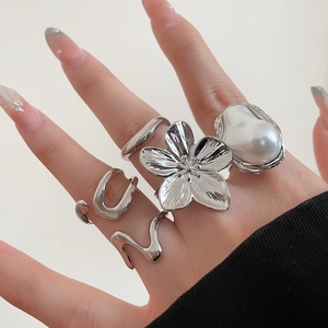Detailed close-up of a silver-plated flower ring with baroque pearl and wavy band set