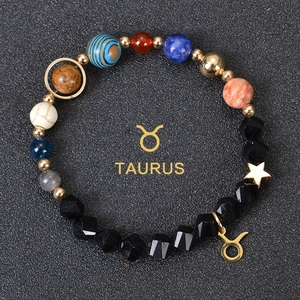 Close-up of Taurus constellation bracelet with cosmic planet beads and golden charm