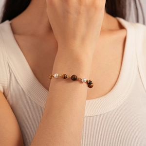 Détail d'un bracelet vintage avec pierres œil de tigre et perles sur le poignet