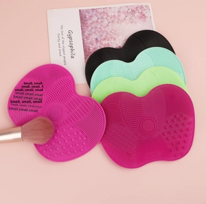 Macro shot of heart-shaped silicone brush cleaning mats with diverse textures and colors