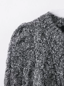 Detailed macro view of black and white cable knit texture with structured puff sleeve