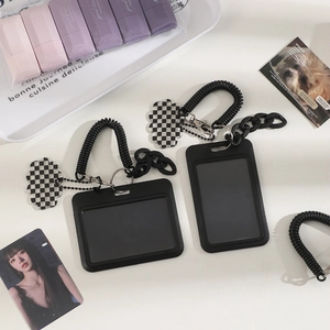 Detail of black card holders with spring lanyard and checkerboard cloud charm