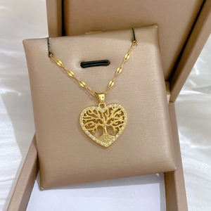 Close-up of golden tree of life heart pendant with white zircon inlays on satin