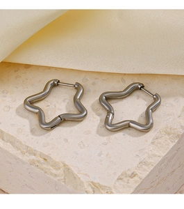 Détail de boucles d'oreilles en forme d'étoile sur fond de pierre et de soie douce