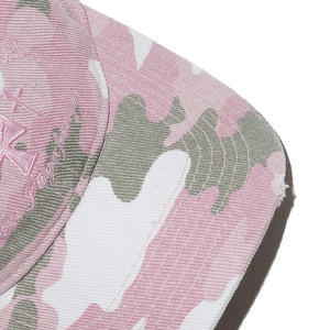 Close-up of pink camo baseball cap with vintage distressed edges and embroidery detail