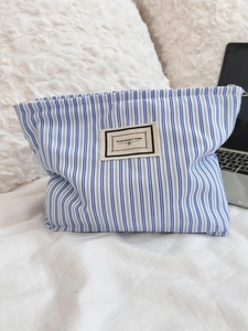 Blue and white striped canvas cosmetic bag with Pleasant Time label for travel storage