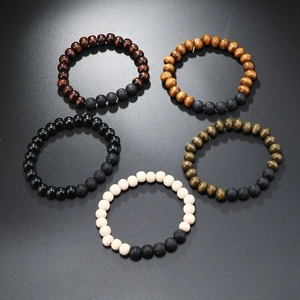 Detail view of five handmade beaded bracelets featuring wood and lava stone in multiple colors
