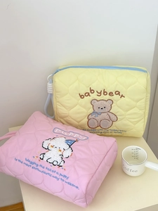 Detail of quilted cosmetic bags with cute bear and puppy embroidery and zipper handles