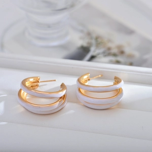 Elegant triple-layered gold hoop earrings with white enamel finish for a chic look