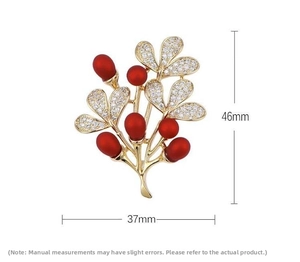 Macro detail of golden branch brooch with red gemstones and crystals, sized 46mm by 37mm
