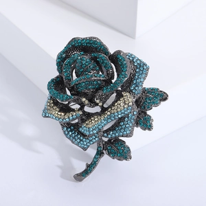 Luxurious rose flower brooch with blue and yellow rhinestones on gun black metal