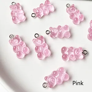 Macro detail of translucent pink resin gummy bear charms with metal jewelry loops