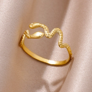 Detail of snake-shaped ring in gold finish on elegant silk background with matte texture