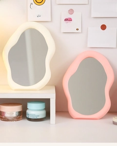 Detail of irregular cloud-shaped desk mirrors in creamy white and pink frames