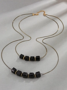 Collar de doble capa con cadena de serpiente dorada, cuentas geométricas negras y cierre ajustable