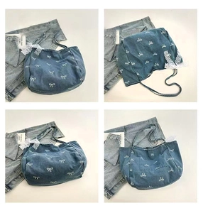 Detail view of denim tote bag with white bow patterns and elegant lace streamers