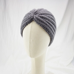 Close-up of a dark grey knit headband featuring a thick texture and stylish knot design