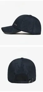 Detail of dark blue quilted baseball cap with metal logo and elastic back strap