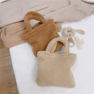 Flat lay di borse tote in peluche color caramello e crema con accessori invernali
