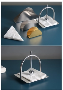 Close-up of stainless steel napkin holders in silver and gold with weighted bar design
